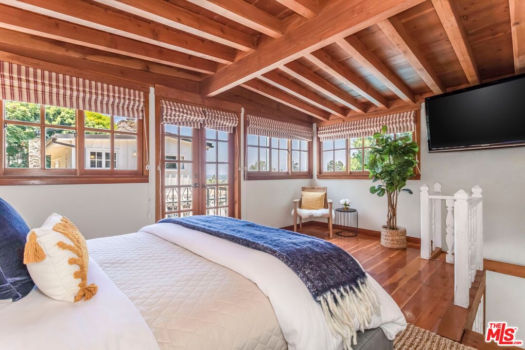 3940 Davana Road Sherman Oaks, CA 91423 - Photo 42 of 60 a bedroom with a large bed and a flat tv screen