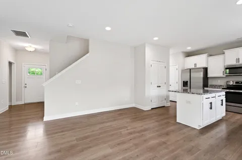 a view of kitchen with stainless steel appliances refrigerator stove microwave and cabinets