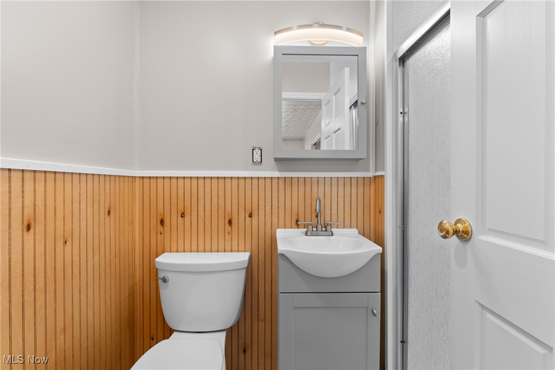 61899 Webb Heights Road Shadyside, OH 43947 - Photo 17 of 39 Bathroom with vanity, toilet, and wood walls