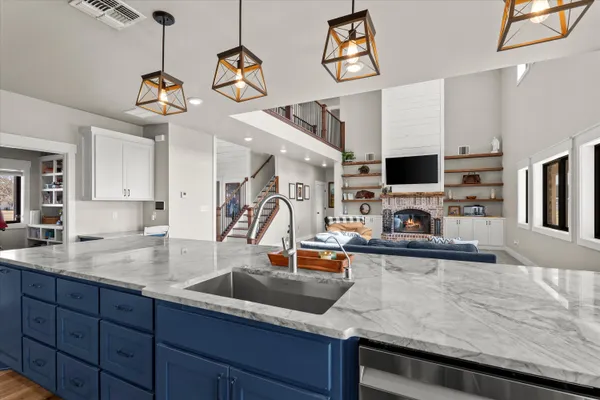 a kitchen with stainless steel appliances kitchen island granite countertop wooden cabinets a stove a sink and dishwasher