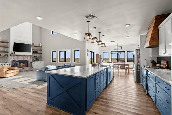 a kitchen with stainless steel appliances granite countertop a kitchen island a stove and a refrigerator