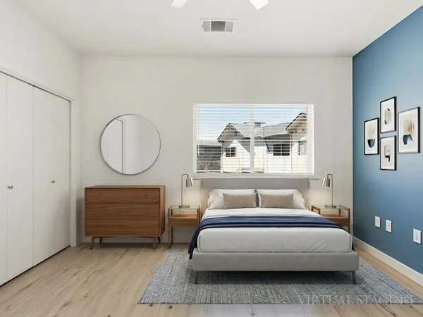 a bedroom with a bed a mirror and a window