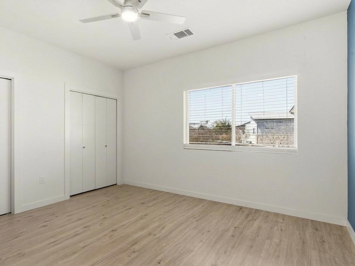 7805 Cooper Lane, Unit 608 Austin, TX 78745 - Photo 17 of 31 a view of an empty room with wooden floor and a window