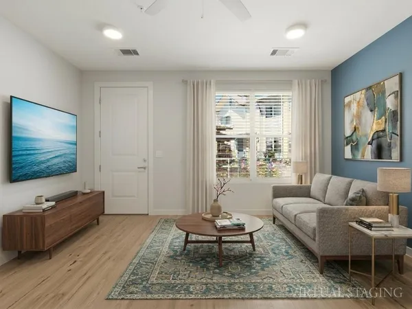 a living room with furniture a rug and a flat screen tv
