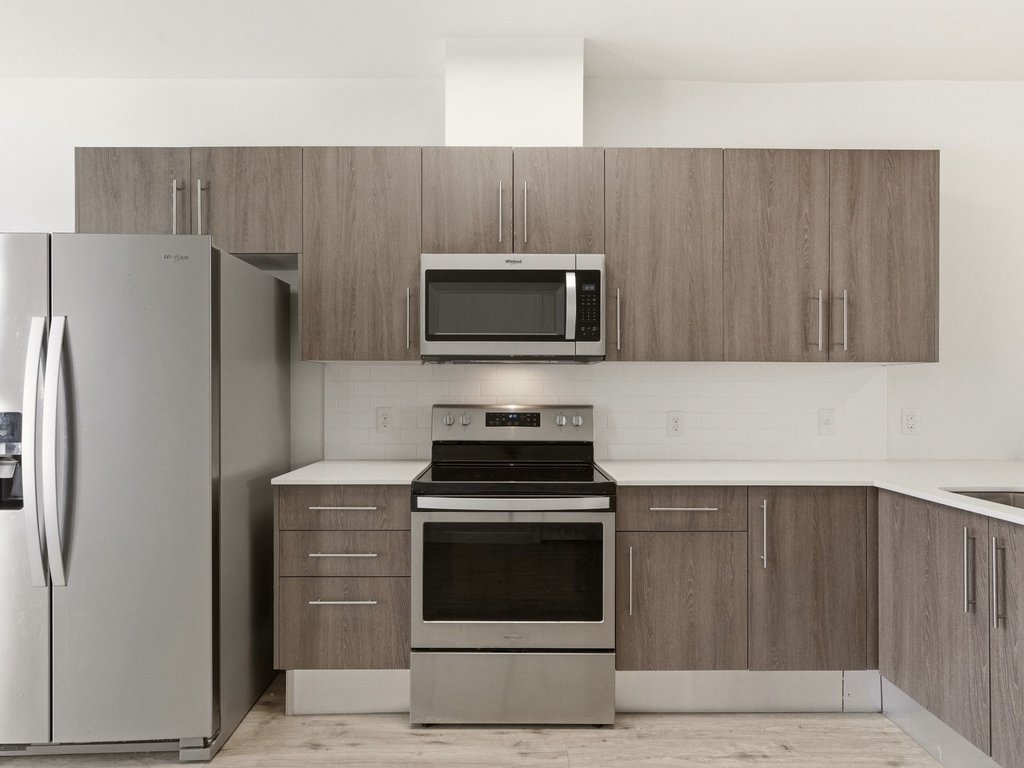 7805 Cooper Lane, Unit 608 Austin, TX 78745 - Photo 8 of 31 a kitchen with granite countertop a stove and a microwave with cabinets