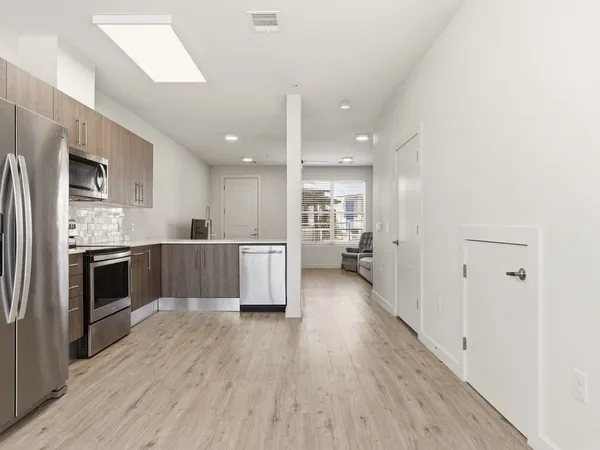 a large kitchen with a wooden floor and stainless steel appliances