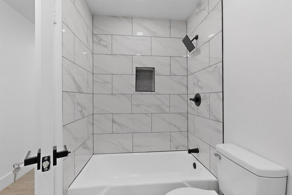 3318 Ridgefield Street Irving, TX 75062 - Photo 20 of 33 a bathroom with a bathtub and toilet