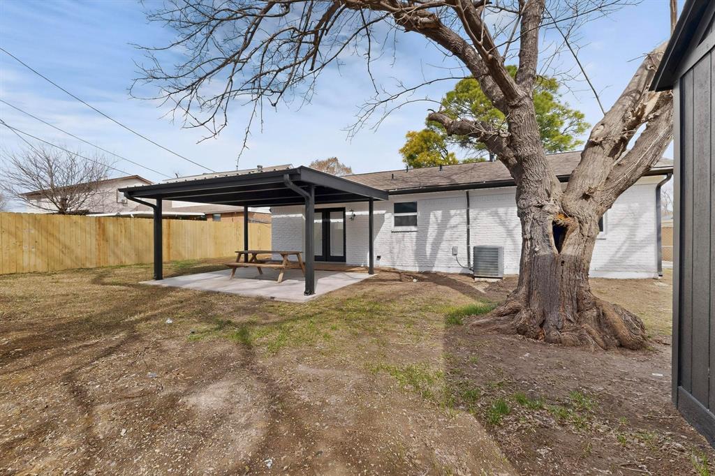 3318 Ridgefield Street Irving, TX 75062 - Photo 28 of 33 a view of a backyard with a table and chair under an umbrella