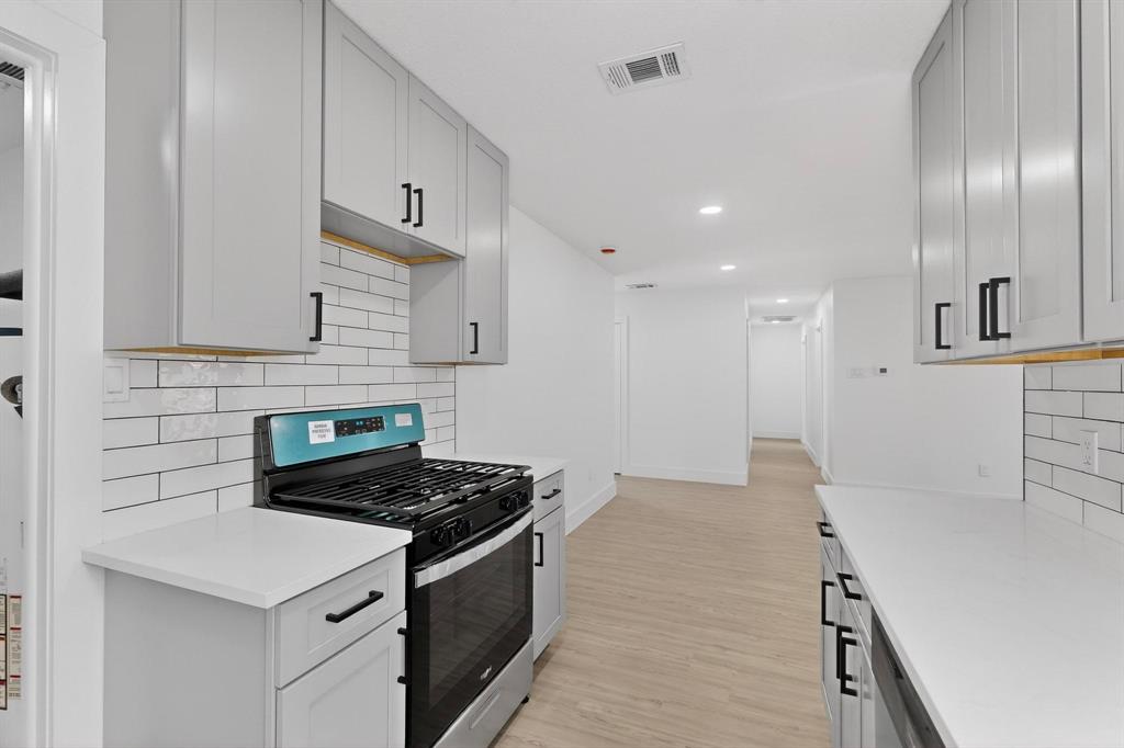 3318 Ridgefield Street Irving, TX 75062 - Photo 10 of 33 a kitchen with stainless steel appliances granite countertop a stove a sink and a refrigerator