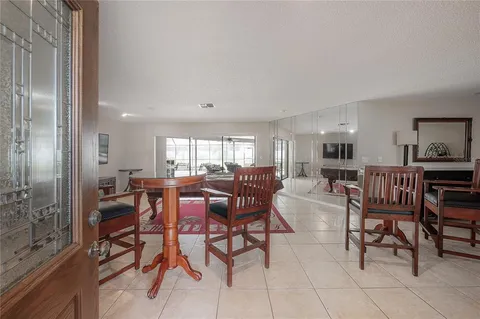 a living room with furniture a ceiling fan and a large window