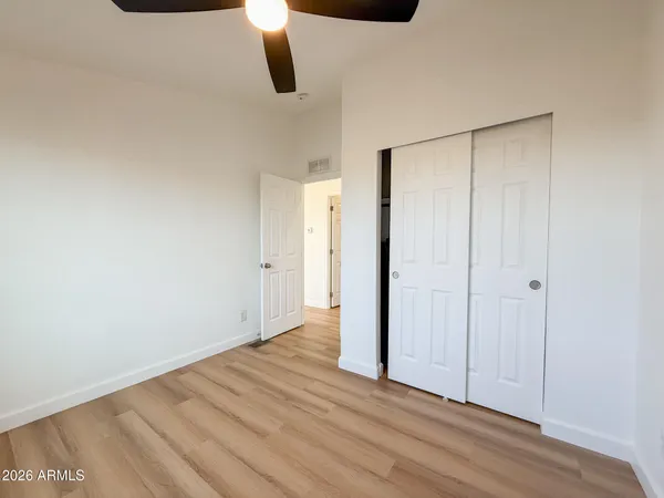 an empty room with a window and a ceiling fan