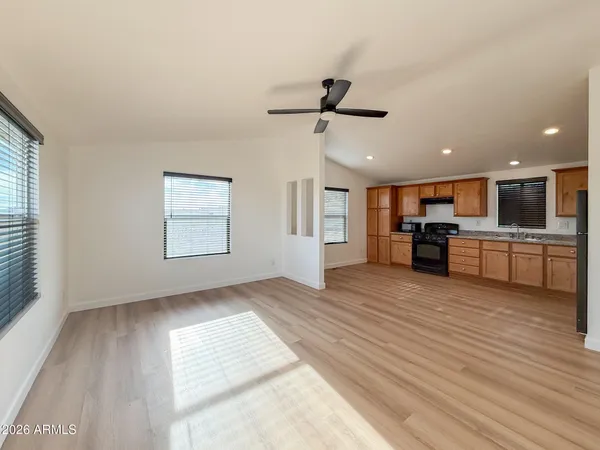 a view of empty room with wooden floor and window