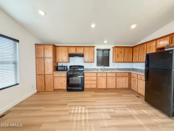 a large kitchen with granite countertop a lot of counter space and stainless steel appliances
