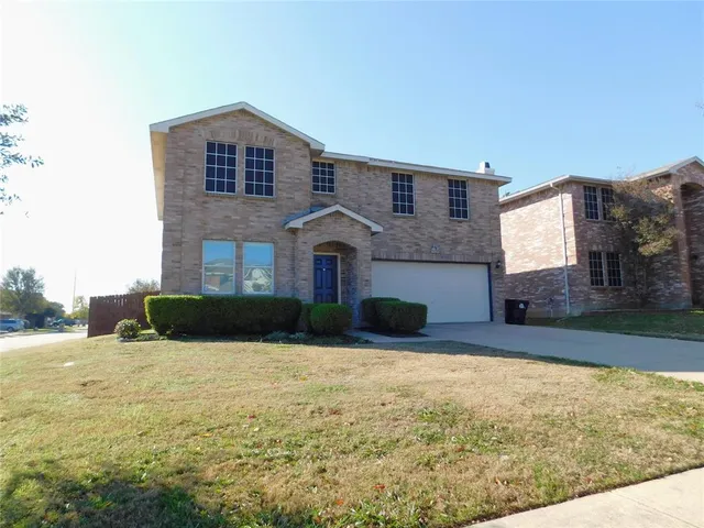 a front view of a house with yard and garage
