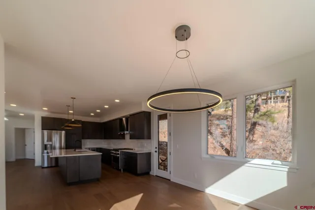 a kitchen with kitchen island a stove and a large window