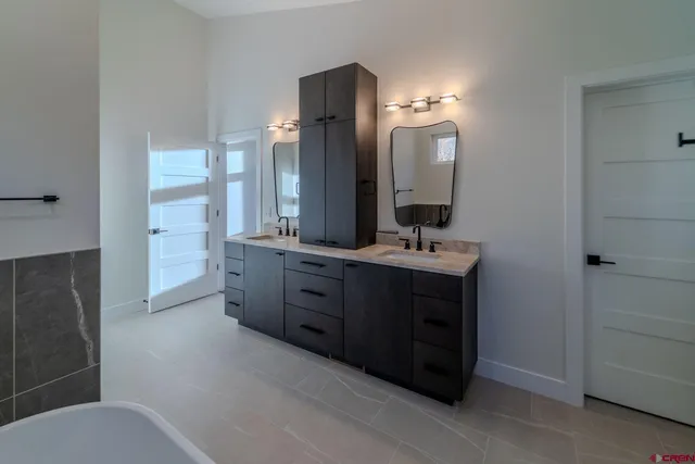 a bathroom with a double vanity sink and a mirror