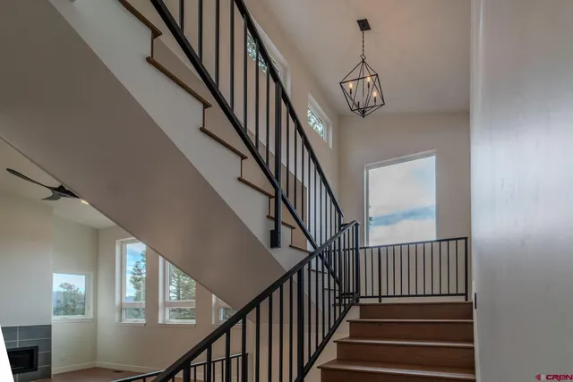 a view of staircase with wooden floor and white walls