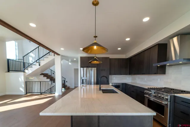 a kitchen with stainless steel appliances granite countertop a sink a stove and a refrigerator