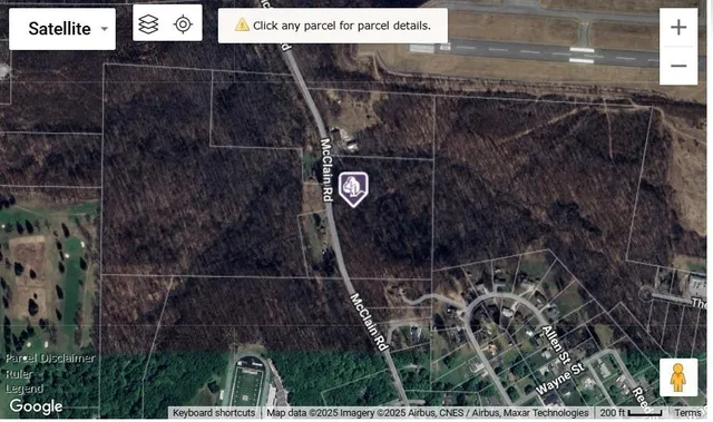 an aerial view of residential house with outdoor space and trees all around