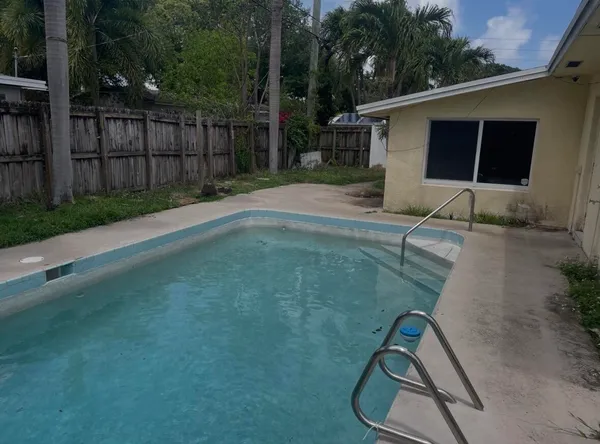 a backyard of a house with wooden floor yard and potted plants