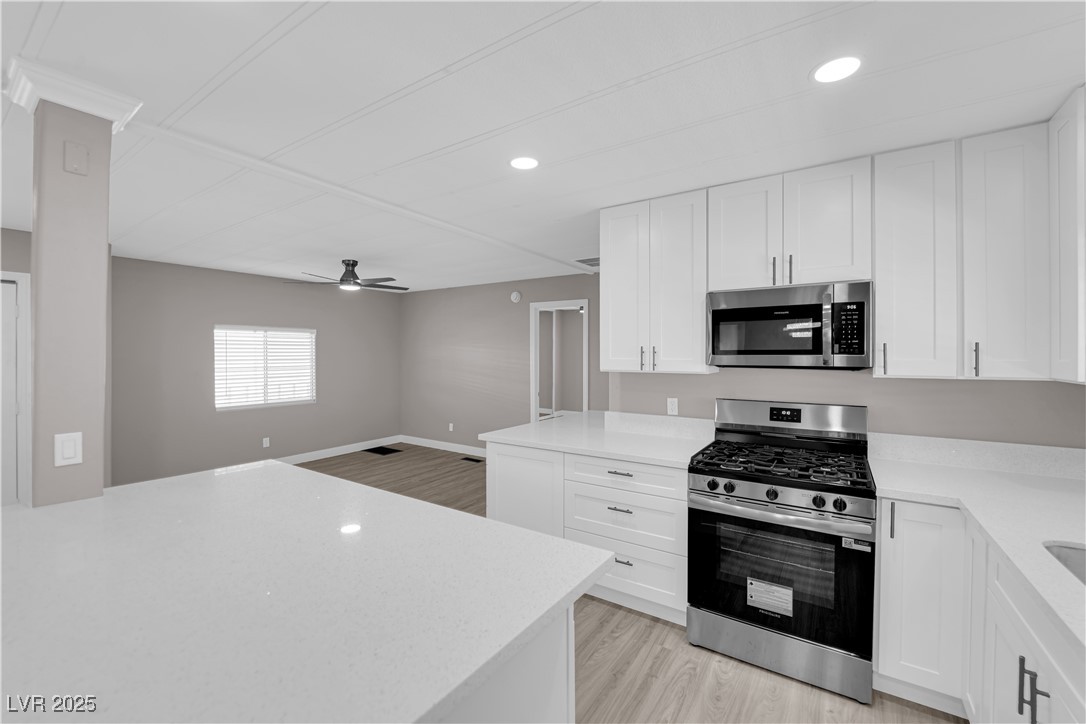 5175 Ridge Drive, Unit 149 Las Vegas, NV 89103 - Photo 15 of 33 Kitchen with appliances with stainless steel finishes, white cabinetry, light wood-style flooring, and recessed lighting