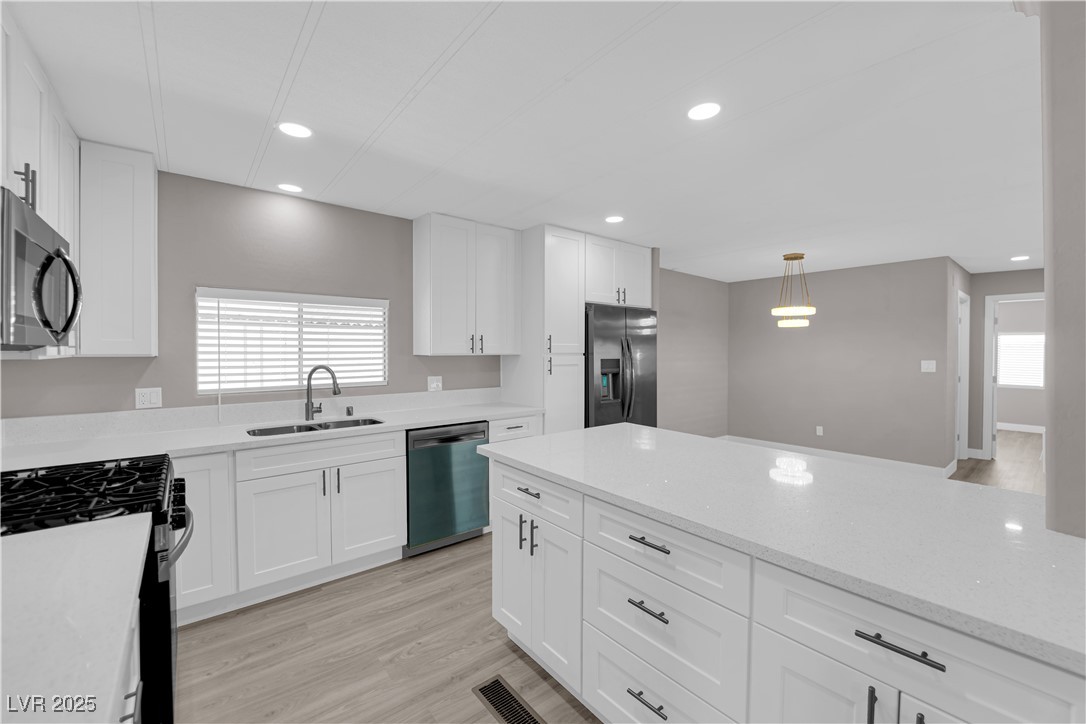 5175 Ridge Drive, Unit 149 Las Vegas, NV 89103 - Photo 16 of 33 Kitchen with appliances with stainless steel finishes, white cabinets, light stone countertops, recessed lighting, and decorative light fixtures