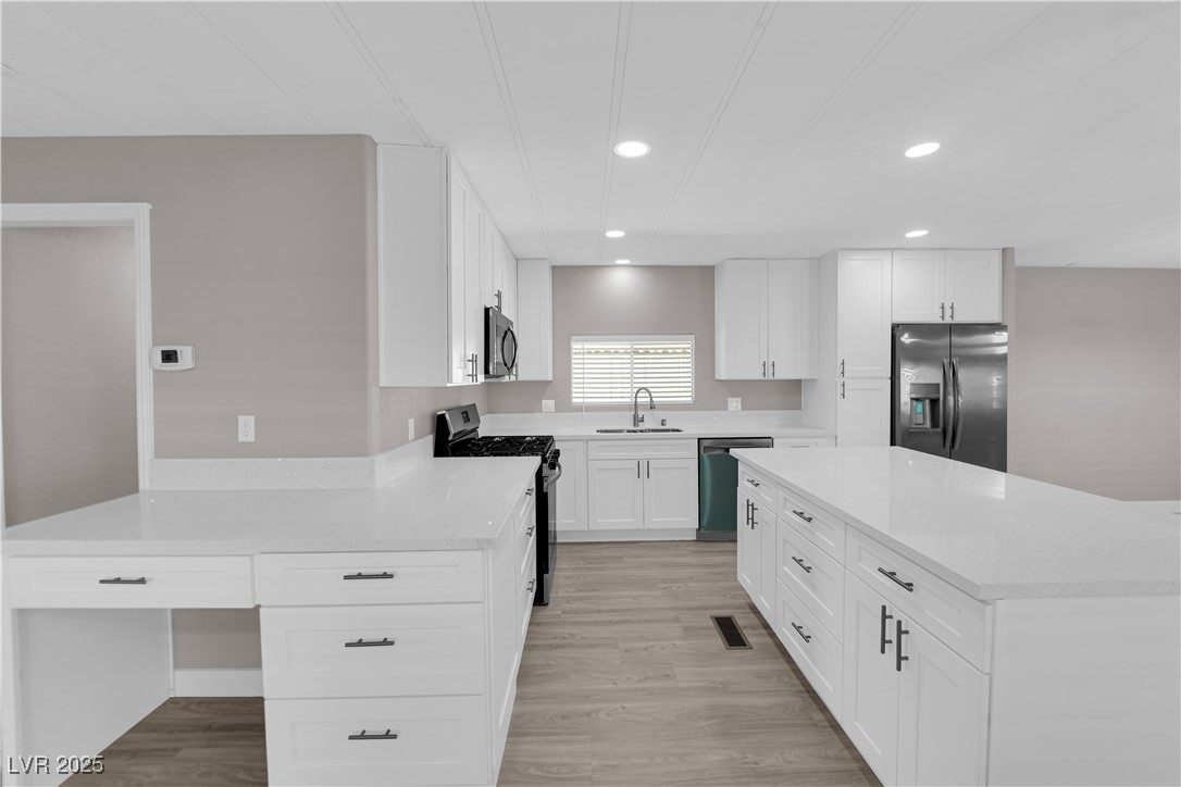 5175 Ridge Drive, Unit 149 Las Vegas, NV 89103 - Photo 17 of 33 Kitchen with stainless steel appliances, light wood-style floors, white cabinets, light stone countertops, and recessed lighting
