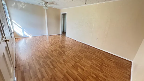an empty room with wooden floor and entrance