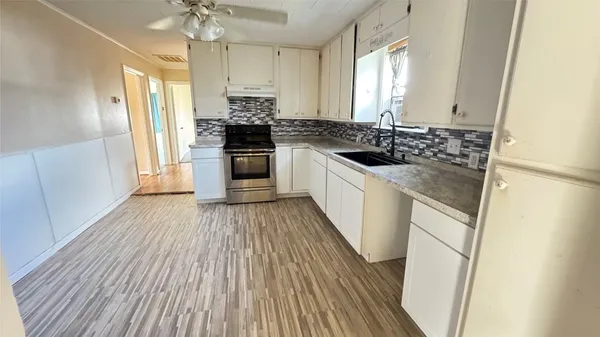 a kitchen with granite countertop a sink and a stove top oven