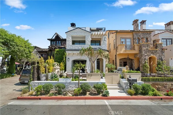 a front view of a building with a garden and plants