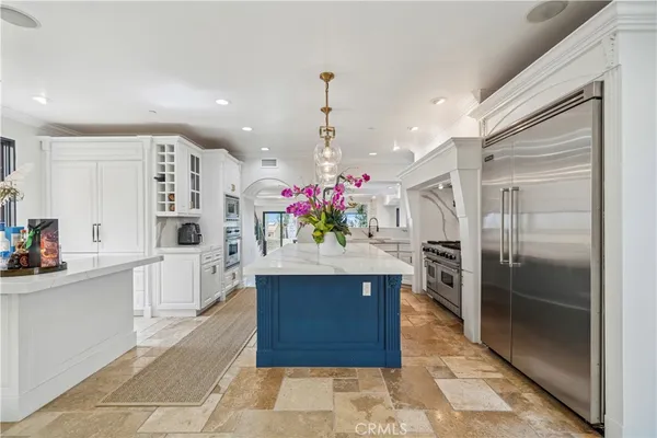 a kitchen with kitchen island granite countertop a refrigerator and a sink