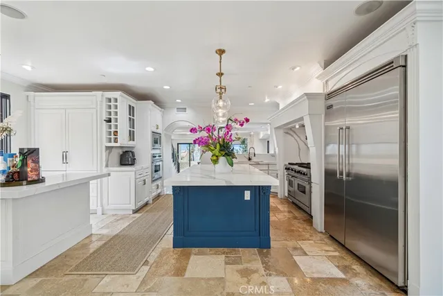 a kitchen with kitchen island granite countertop a refrigerator and a sink