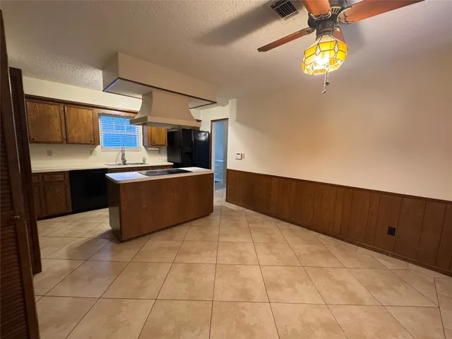 a kitchen with stainless steel appliances a sink a stove a microwave a counter top space and cabinets