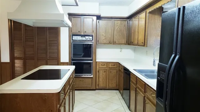 a kitchen with stainless steel appliances granite countertop a refrigerator a stove and a sink