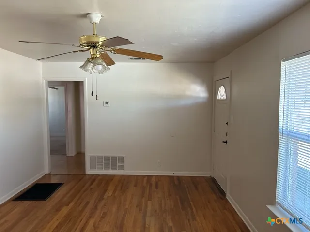 wooden floor in an empty room with a window