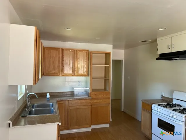 a kitchen that has a sink and a stove in it