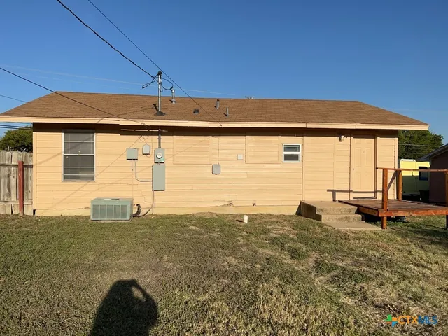 a backyard of a house with table and chairs