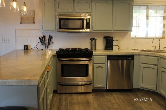 401 Ashton Street Ridgecrest, CA 93555 - Photo 10 of 36 a kitchen with stainless steel appliances granite countertop a stove a microwave and cabinets