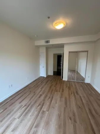 a view of an empty room and window and wooden floor