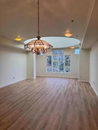 an empty room with windows and ceiling fan