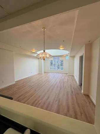 a room with a bed and chandelier fan