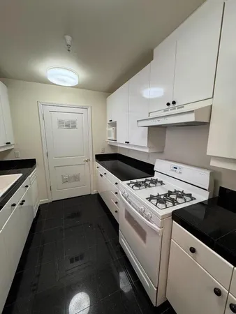 a kitchen with granite countertop cabinets and white stove