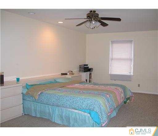 184 Plainfield Road Edison, NJ 08820 - Photo 8 of 12 a bedroom with a bed and a chandelier