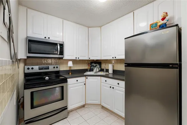 a kitchen with white cabinets and black appliances