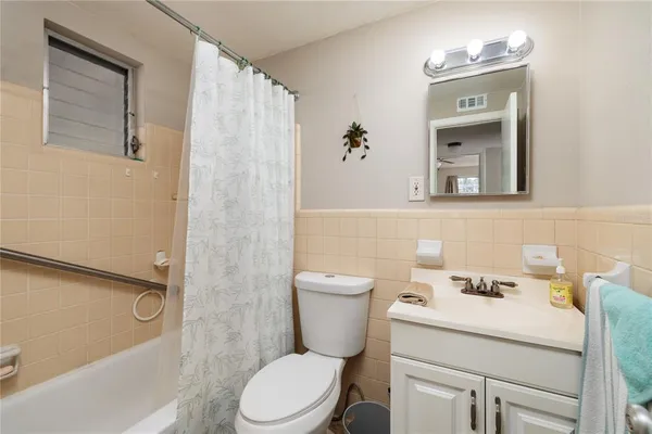 a bathroom with a sink a toilet and shower curtain