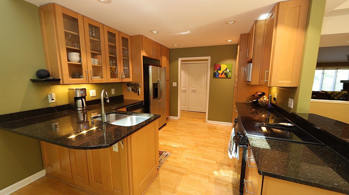 4005 Lake Springs Court Raleigh, NC 27613 - Photo 13 of 38 featuring glass cabinetry and wood cabinets Kitchen