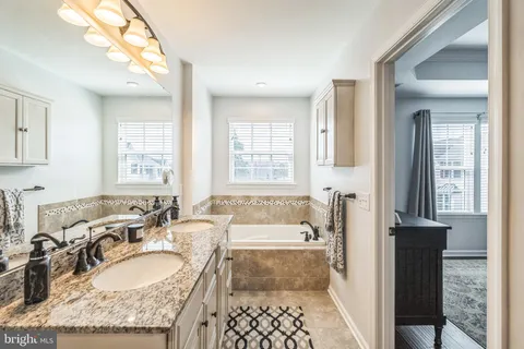 a spacious bathroom with sinks mirror and a bathtub