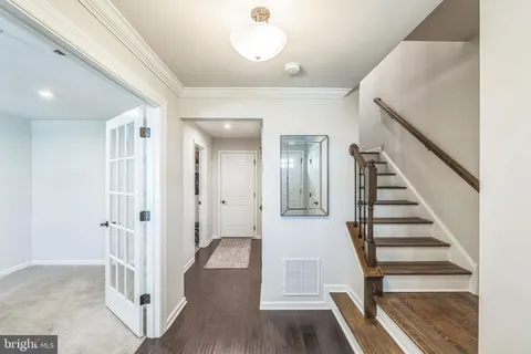 a view of a hallway with wooden floor and entryway