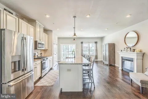 a kitchen with refrigerator a stove and a wooden floors