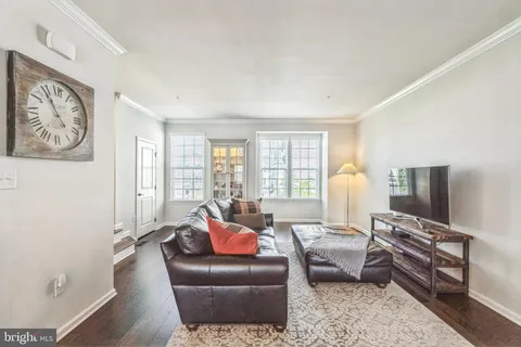 a living room with furniture a flat screen tv and a window